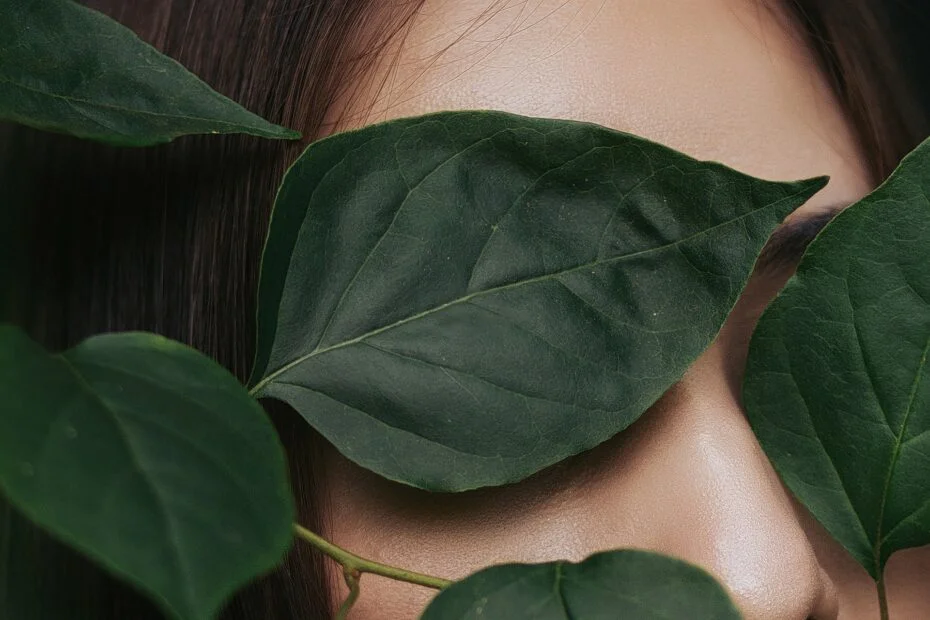 woman with leaves in front of her eyes